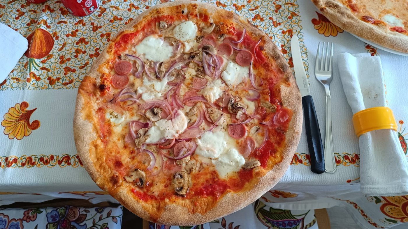 Pizza con mozzarella, cipolla e funghi appena sfornata